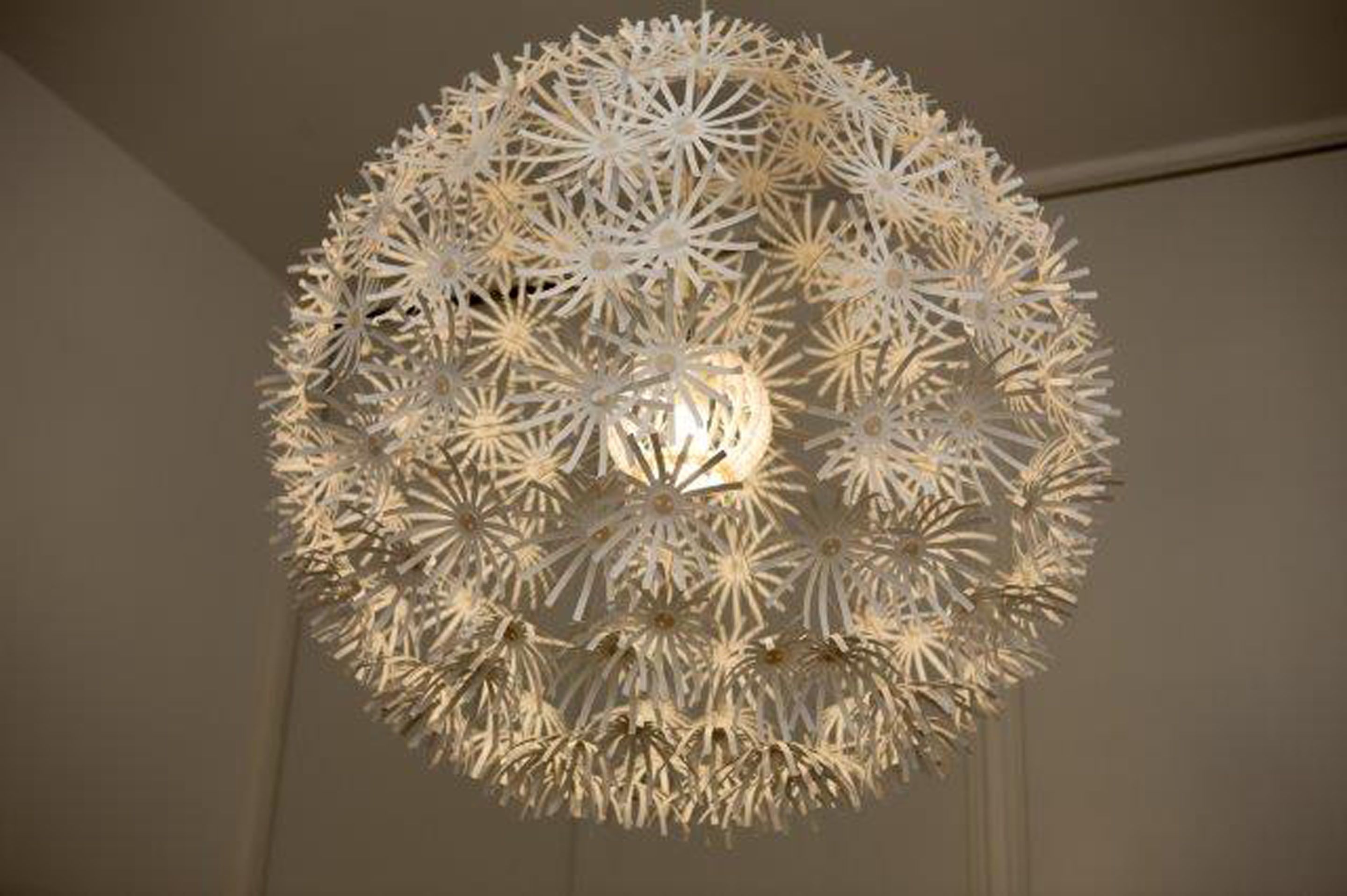 Un lustre sphérique doté d’un design complexe évoquant une étoile.