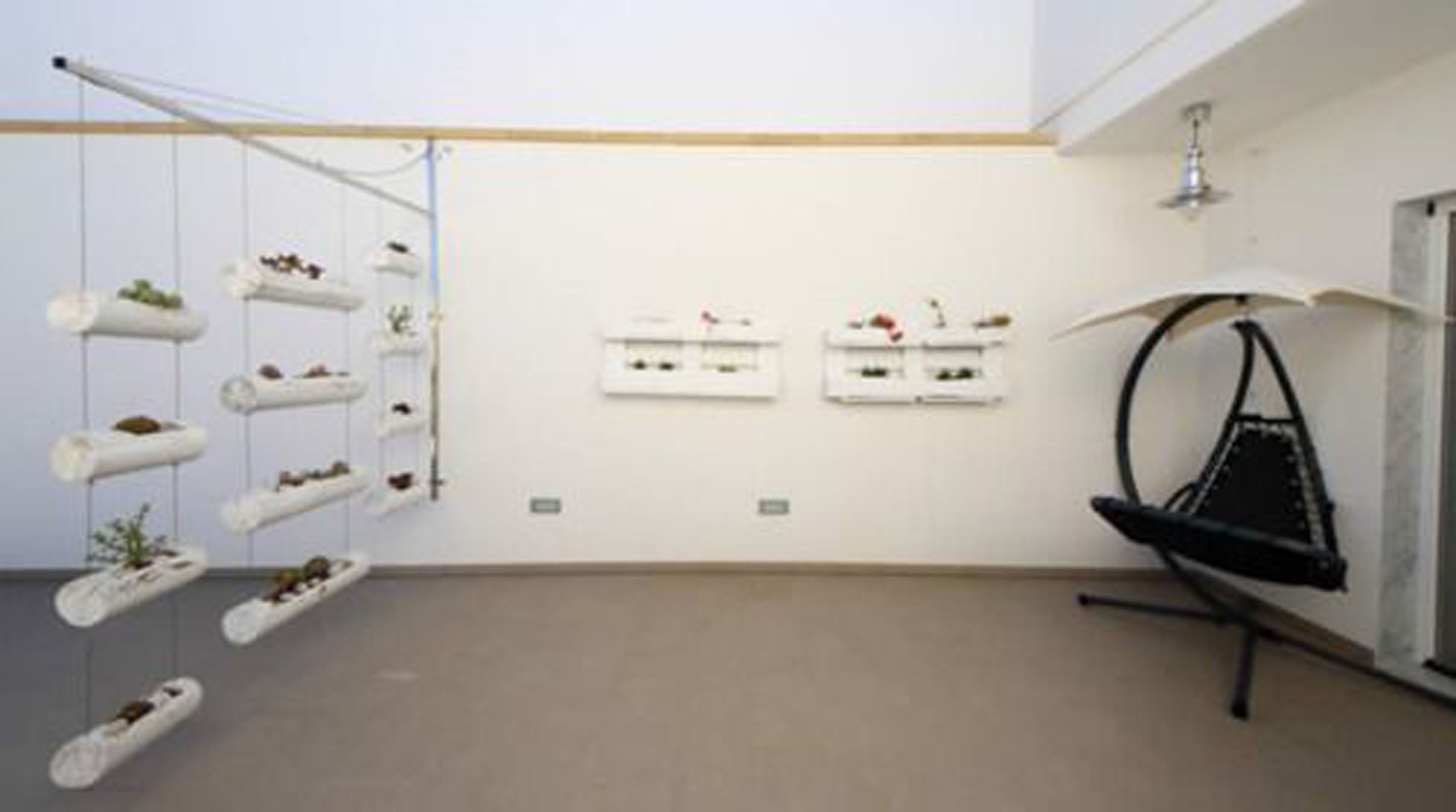 A modern interior with white walls, a hanging chair, and minimalist decor.