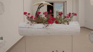 Una jardinera blanca con flores rojas en un balcón.