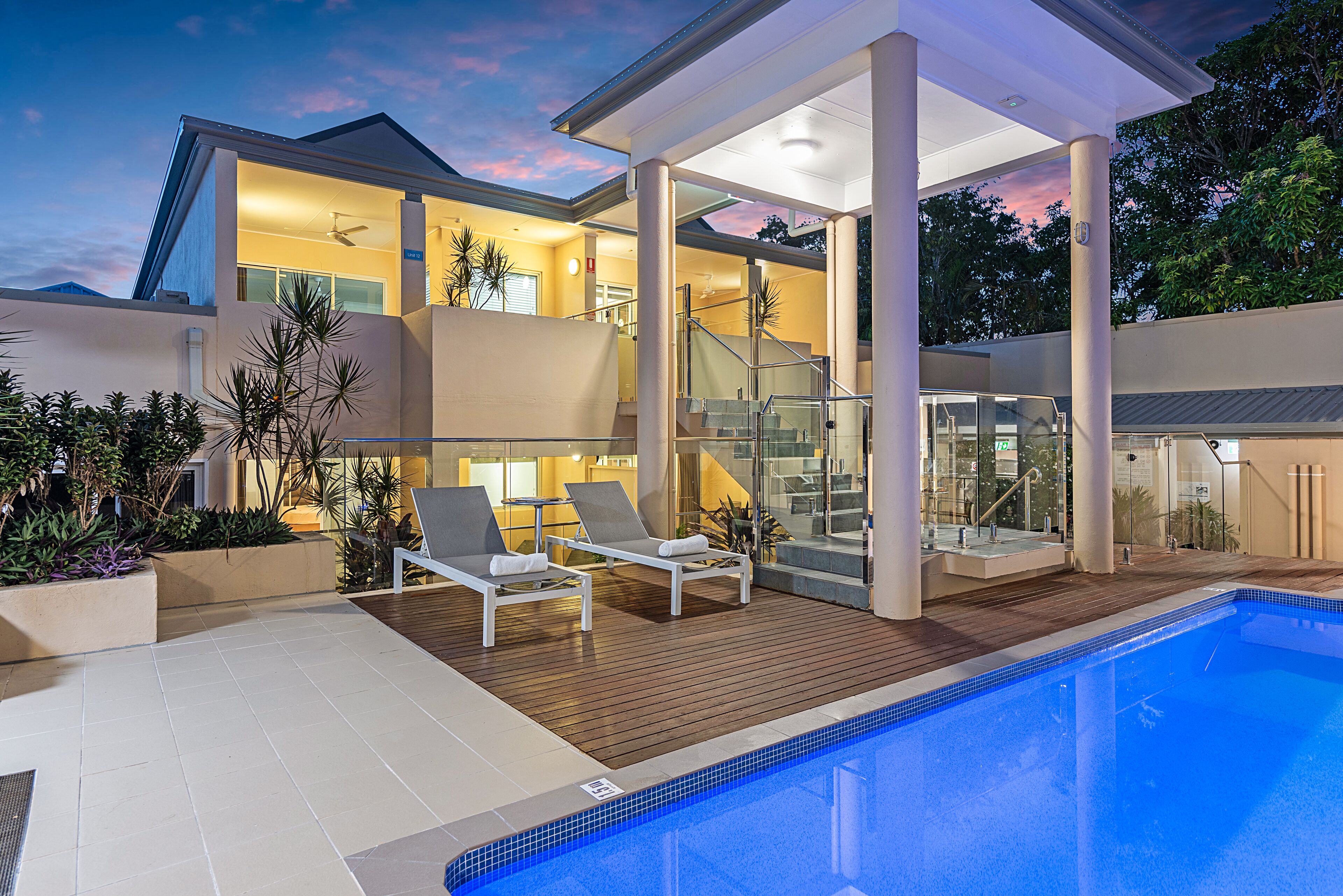 A modern house with a swimming pool, outdoor seating, and a covered patio area.