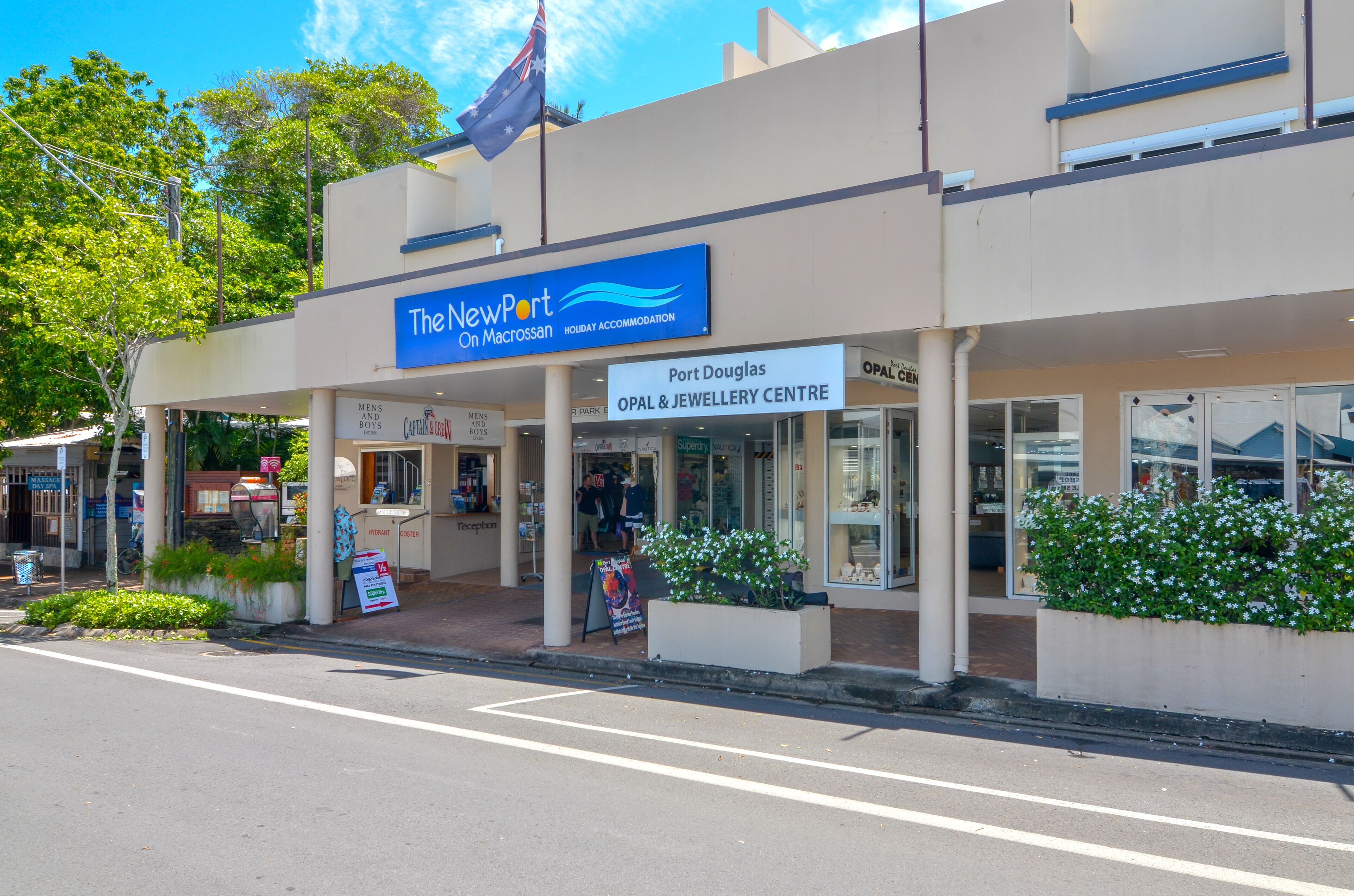 A building with a sign for "The New Port on Macrossan" and "Port Douglas OPAL & JEWELLERY CENTRE".