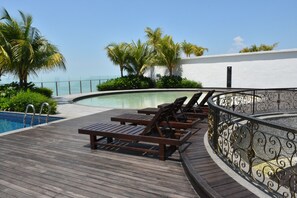 A wooden deck with lounge chairs and a pool. - Silverscape Family Studio Suite (Malacca City)