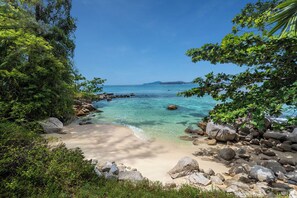On the beach, white sand, sun loungers, beach umbrellas