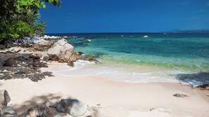 On the beach, white sand, sun loungers, beach umbrellas