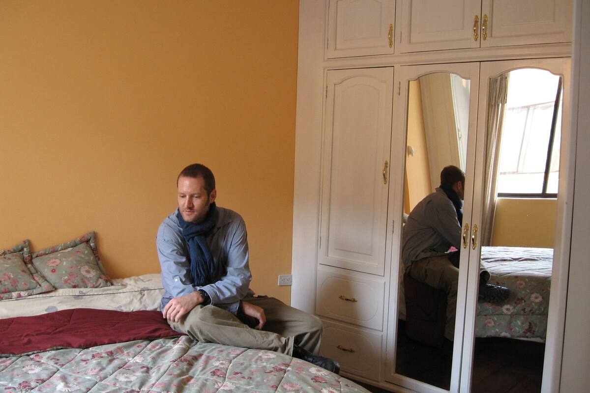 Een slaapkamer met een bed, een kledingkast en een spiegel.