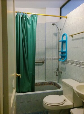 Une salle de bain équipée d’une baignoire, de toilettes et d’un espace douche.