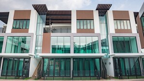 Un hotel moderno de varios pisos, con grandes ventanales, piscina y un diseño arquitectónico contemporáneo.