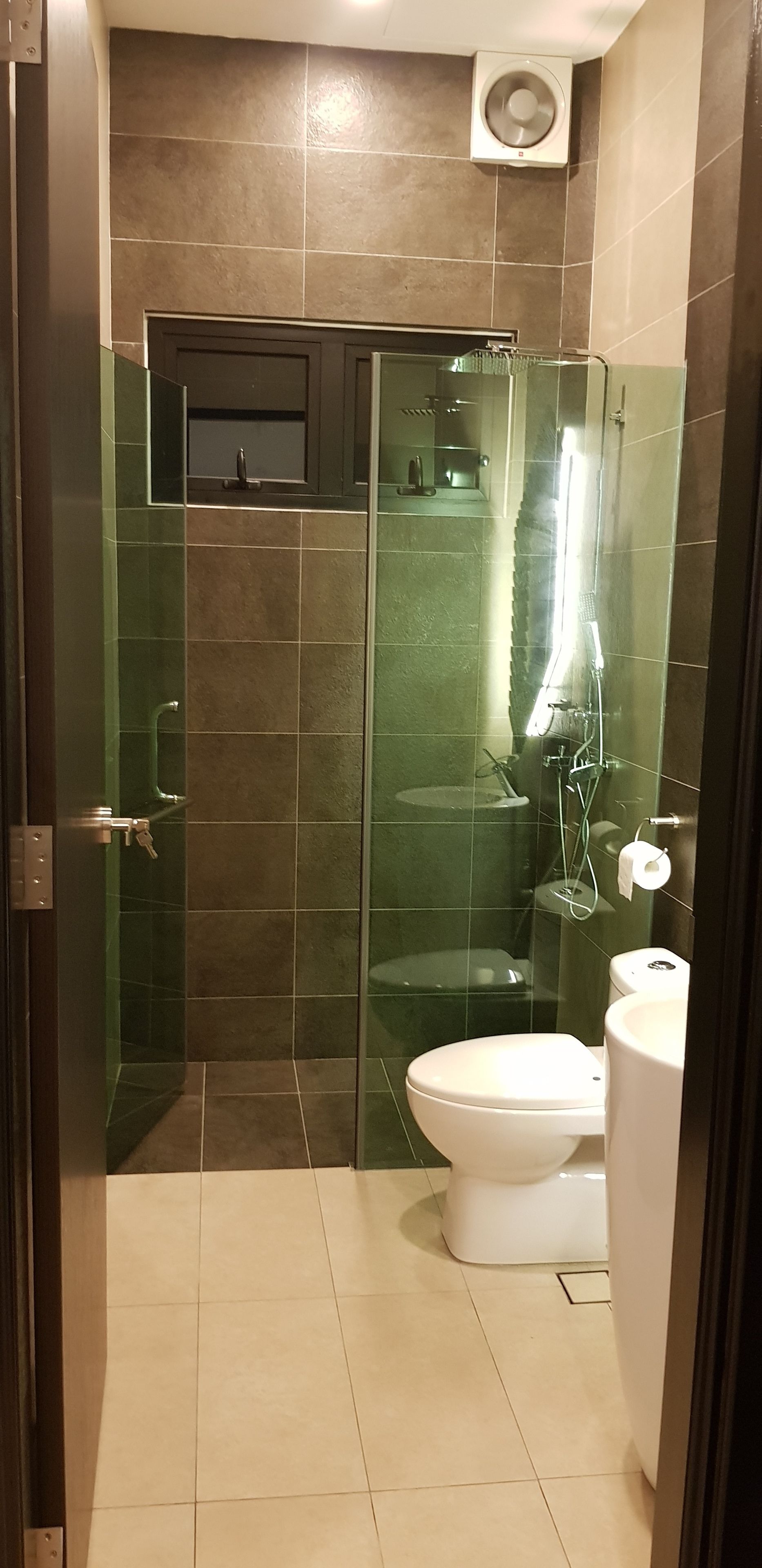 Un baño moderno con ducha de vidrio, inodoro y lavamanos.