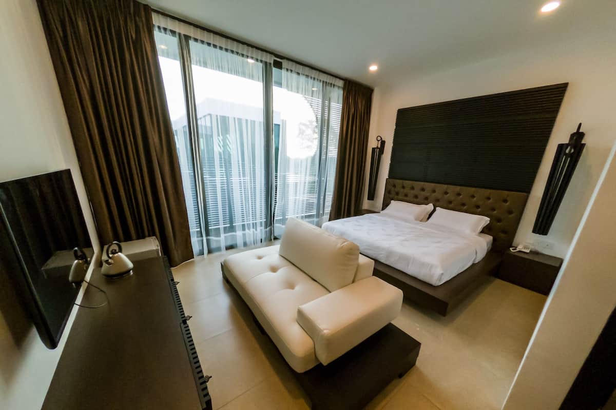 Een moderne hotelkamer met een groot bed, een bank, een bureau en een televisie.