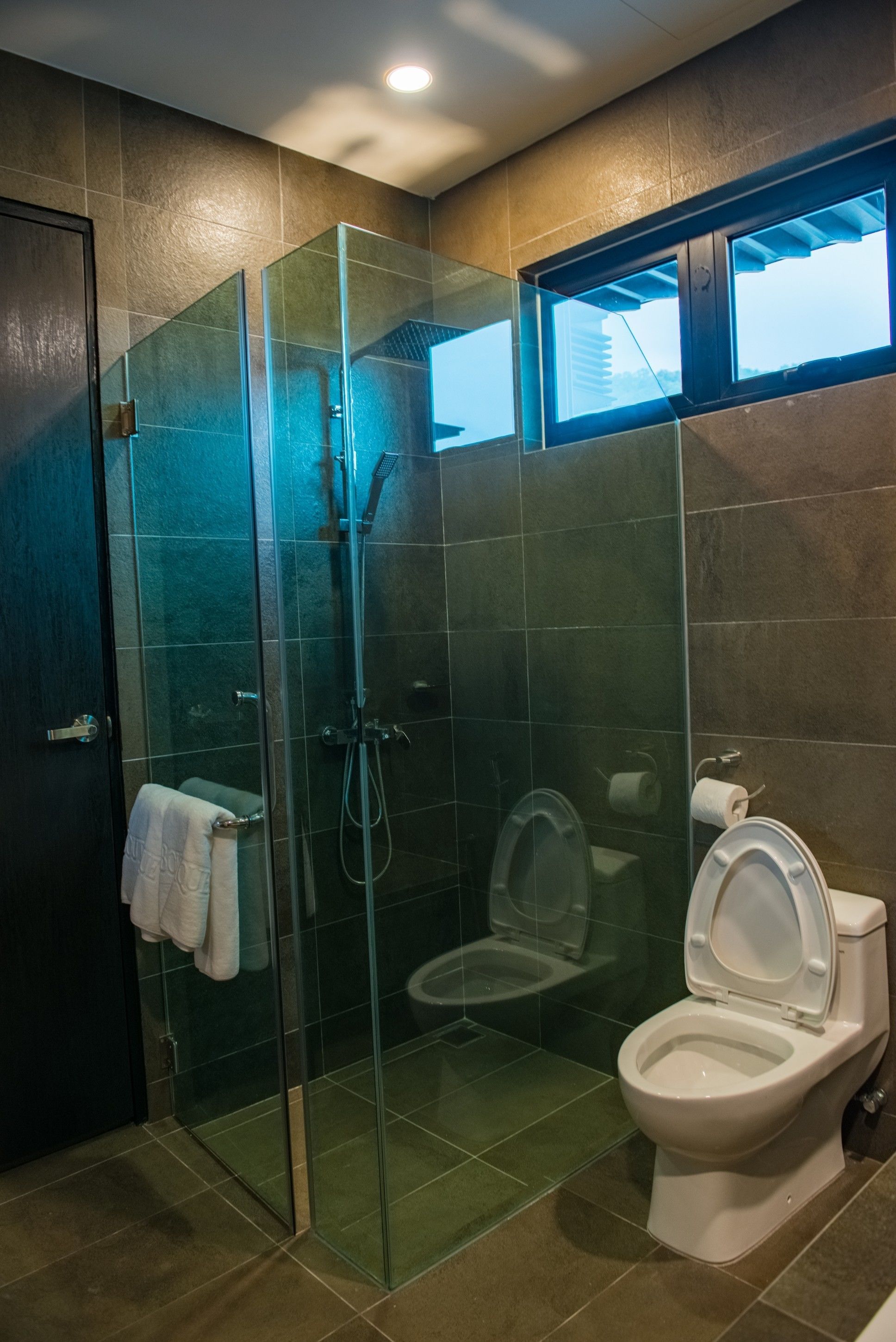Un baño moderno con ducha de vidrio, inodoro y lavamanos.