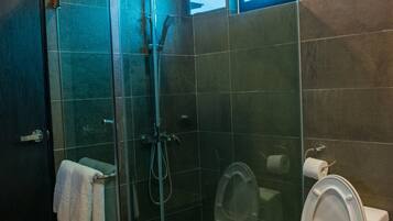 Un baño moderno con ducha de vidrio, inodoro y lavamanos.