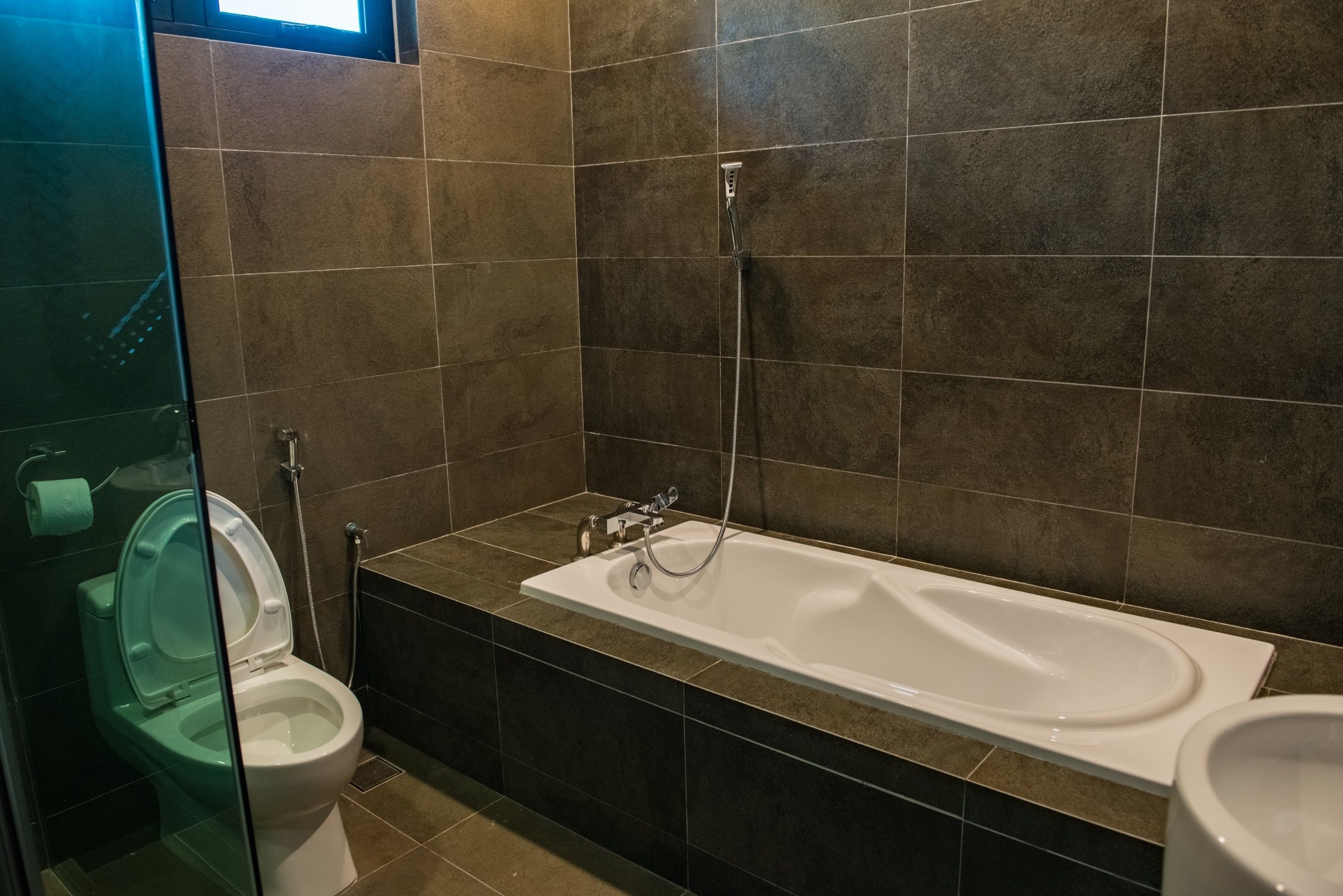 Un baño con bañera, inodoro y cabina de ducha de vidrio.
