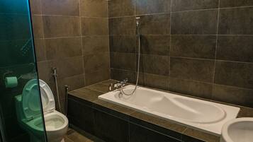 Un baño con bañera, inodoro y cabina de ducha de vidrio.