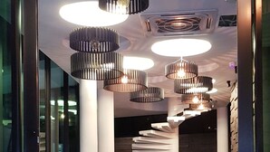 Un vestíbulo moderno con piso de mármol, varias zonas de estar e iluminación contemporánea.