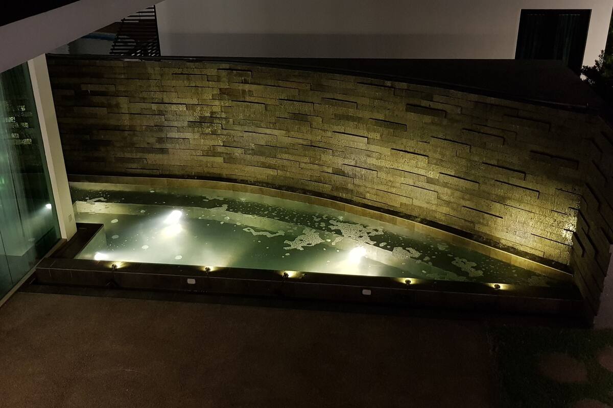 Een wellnessruimte met een stenen muur en een verwarmde vloer.