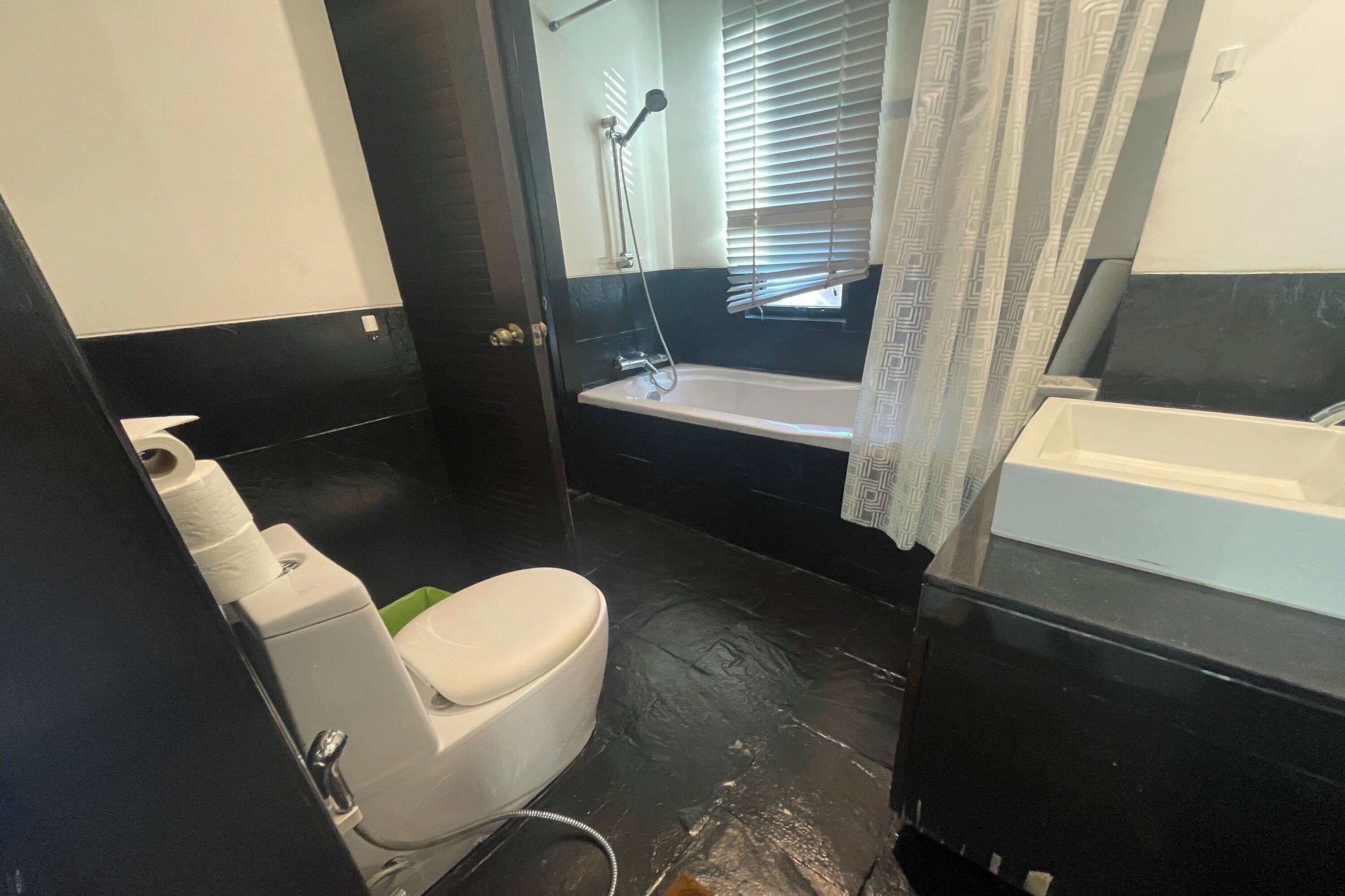 Een kleine badkamer met toilet, bad en wastafel.