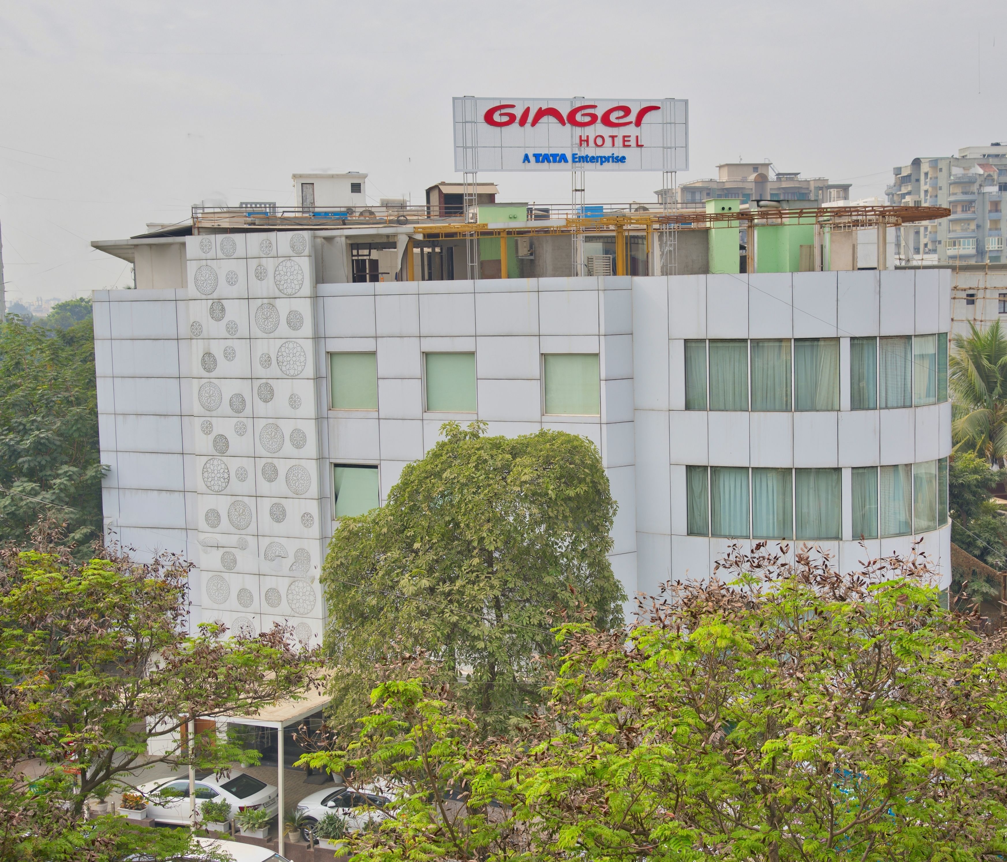 A building with a sign for Ginger Hotel, featuring a modern design with geometric patterns on the facade and multiple windows.
