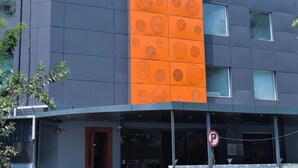 A building with a sign reading "GINGER" and a large orange panel with circular patterns. - Ginger Vadodara RCR (Vadodara)