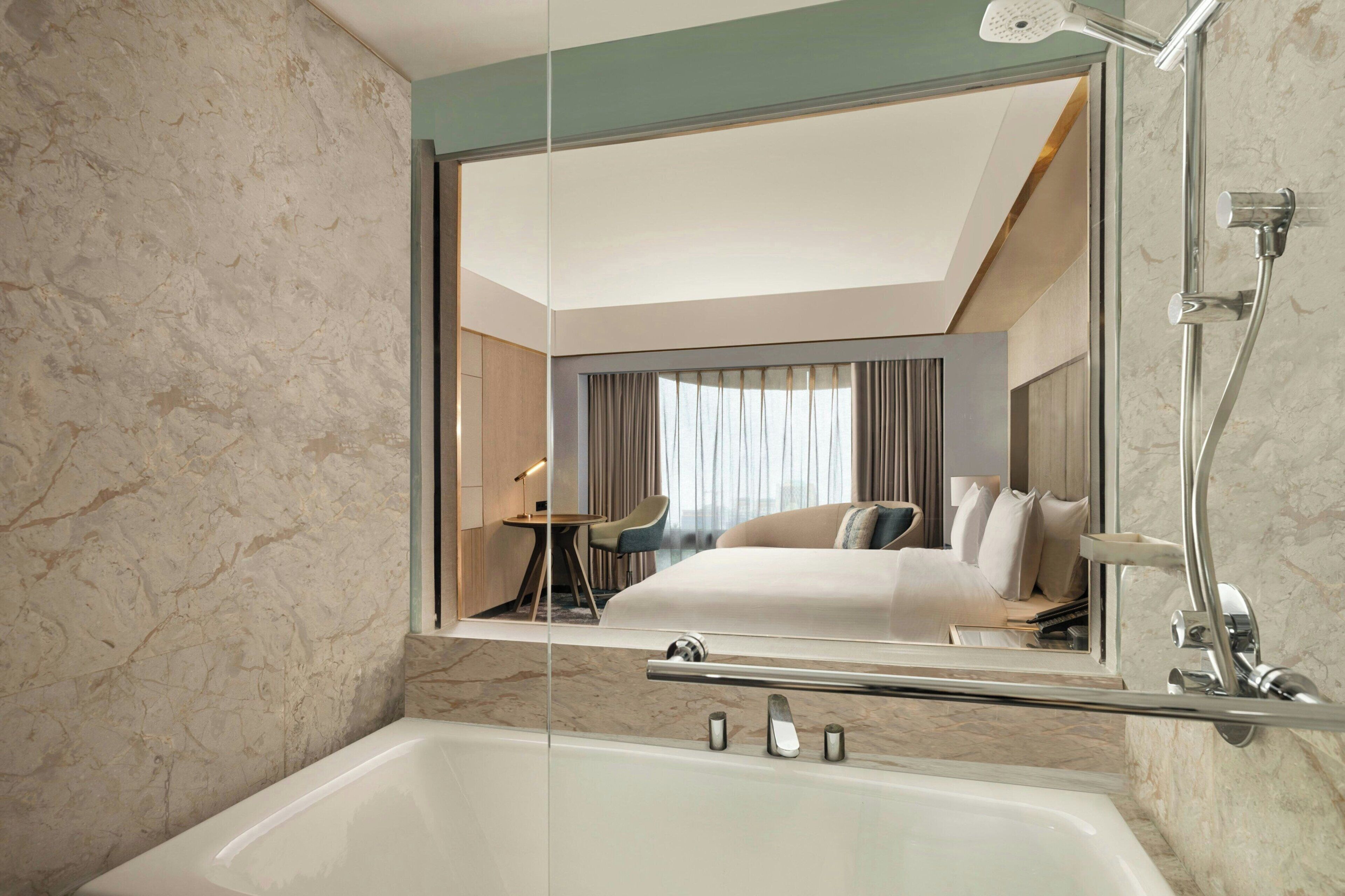 Une salle de bain moderne avec un grand miroir, une baignoire et une douche.