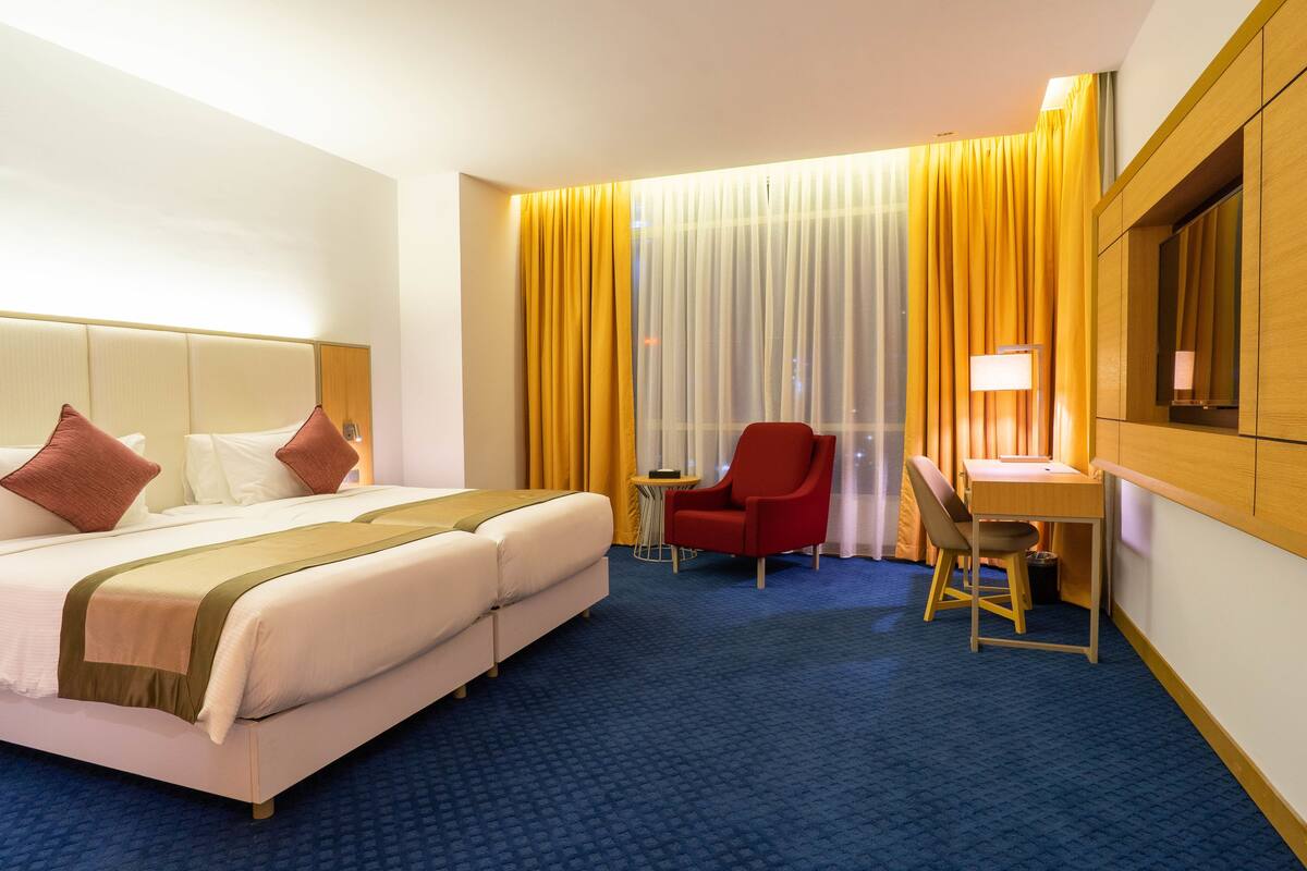 Deluxe kamer | Luxe beddengoed, een minibar, een kluis op de kamer, een bureau
