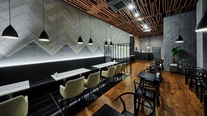 A modern restaurant interior with a herringbone patterned wall, black and white seating, and pendant lighting. - Hotel Riverside (Ulsan)