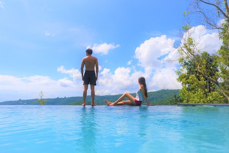Una piscina al aire libre, sillones reclinables de piscina