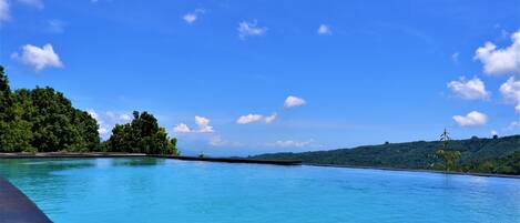 Una piscina al aire libre, tumbonas
