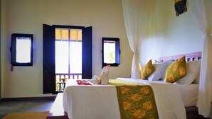 A neatly made bed with a white and green bedspread, two windows with open shutters, and a wooden bench in the foreground. - Swar Bali Lodge (Munduk)