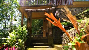 A wooden structure with a sign reading "CHOCOLATE" leading to a stone staircase. - Swar Bali Lodge (Munduk)