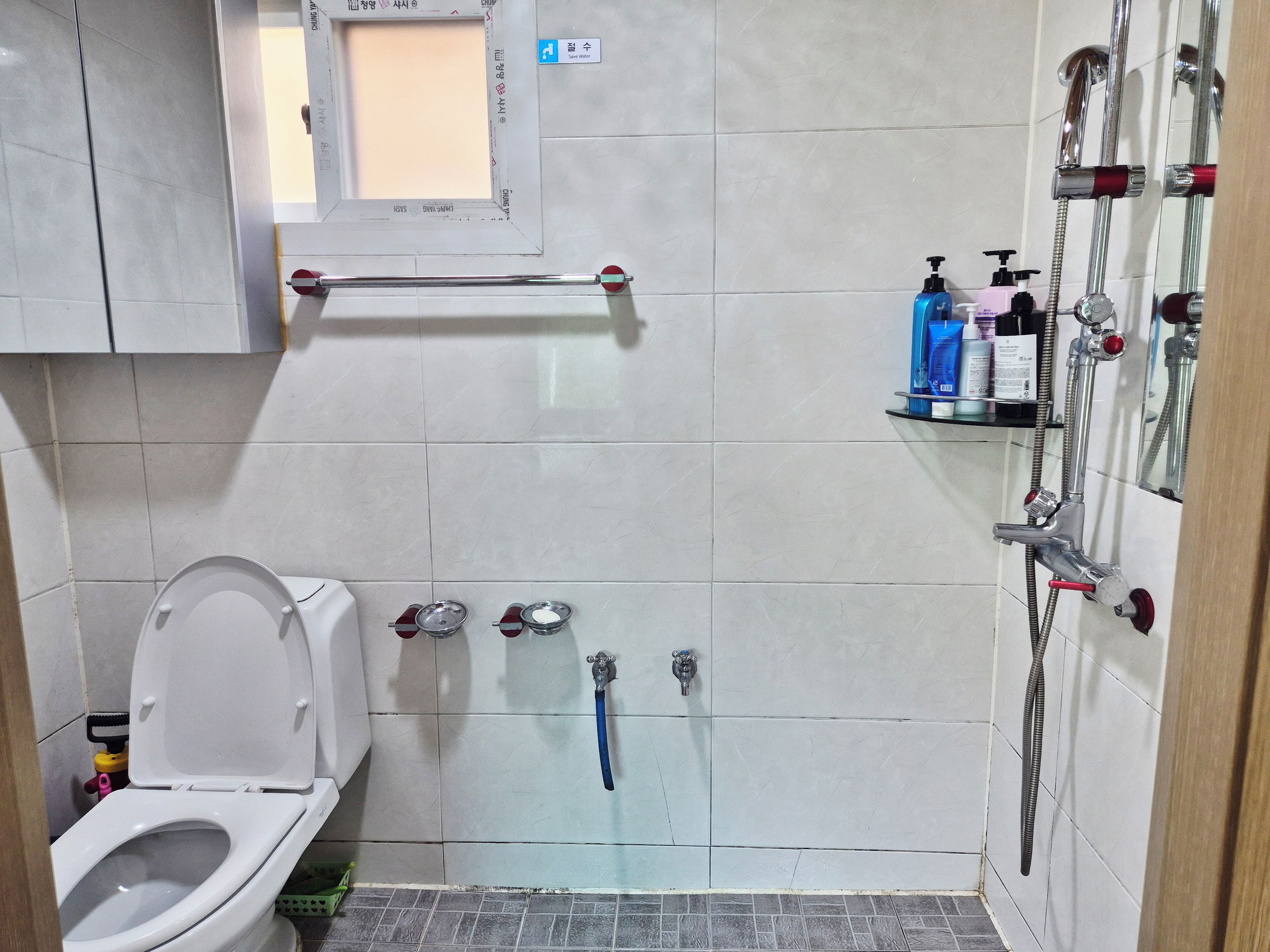 A bathroom with a toilet, a shower, and a sink.