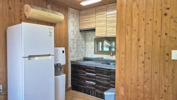 A compact kitchen with a built-in refrigerator, a water dispenser, and a dishwasher.