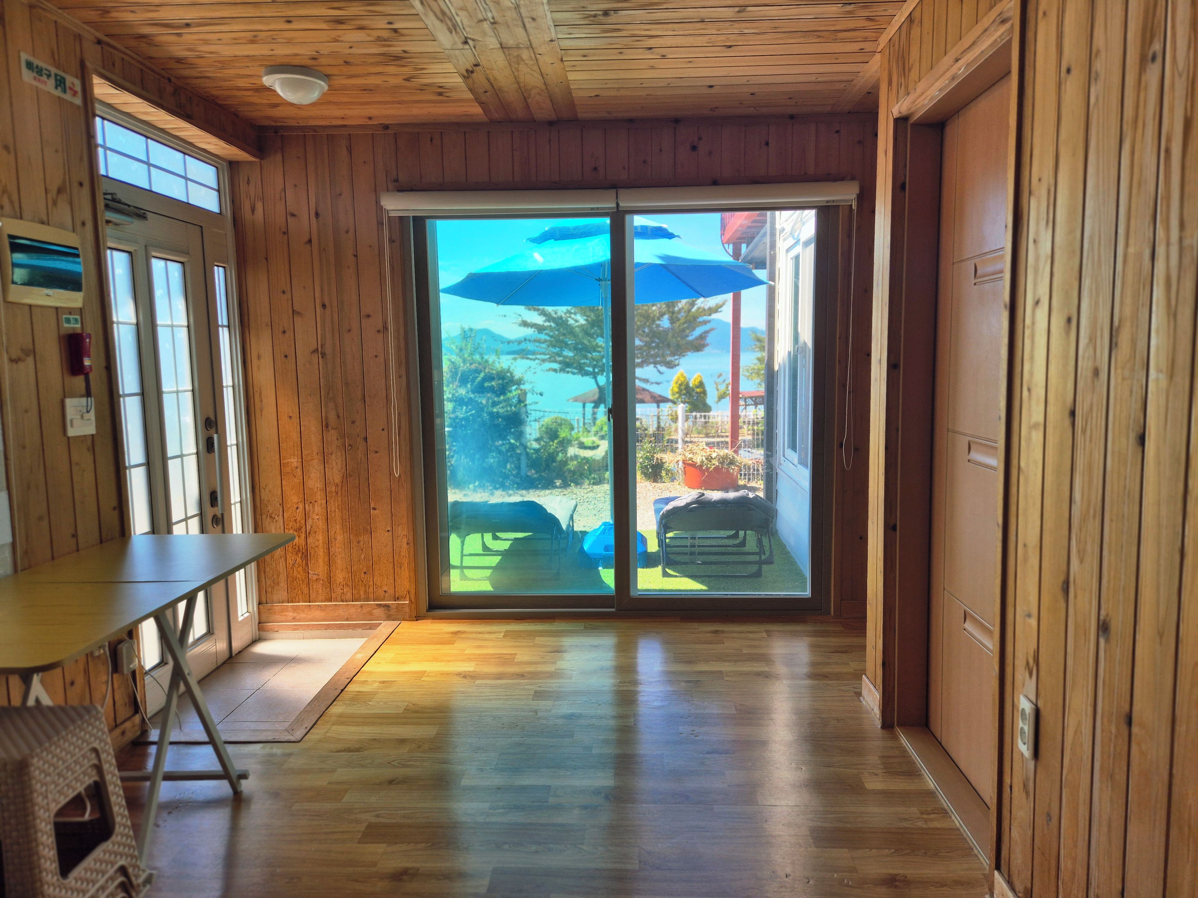 A wooden interior with a sliding glass door leading to an outdoor area.