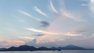 A calm body of water with distant mountains and a clear sky.