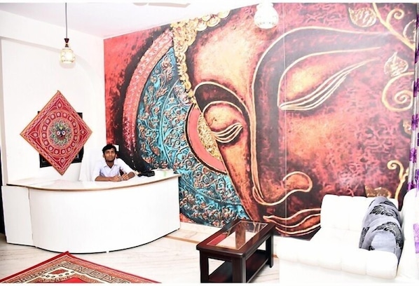 A reception area with a large mural, a reception desk, and a sofa.