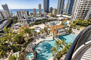 A resort with a large pool, palm trees, and high-rise buildings in the background. - Holiday Holiday Chevron Renaissance (Surfers Paradise)
