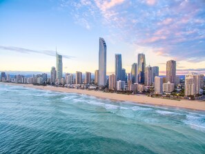 A coastal cityscape with high-rise buildings, a beach, and the ocean.