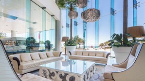 A modern lobby with glass walls, a central coffee table, and seating arrangements. - Holiday Holiday Soul Surfers Paradise (Surfers Paradise)