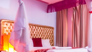 Une chambre à coucher avec un lit en bois, une table de chevet et une commode.