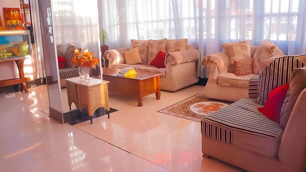 Un salon moderne comprenant un canapé, une table basse et un vase décoratif.