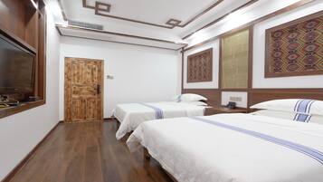 Una habitación de hotel con dos camas, un armario de madera, un televisor y decoración mural.