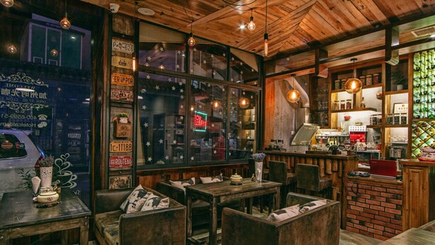 A cozy cafe with wooden furniture, a brick counter, and a large window with star decorations. - Zhangjiajie Shi Guang Zhi Wai Boutique Hotel (Zhangjiajie)