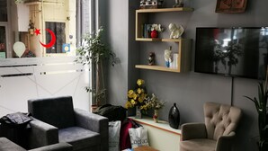 Un soggiorno moderno con divani grigi, un tavolino in legno e un televisore montato a parete.