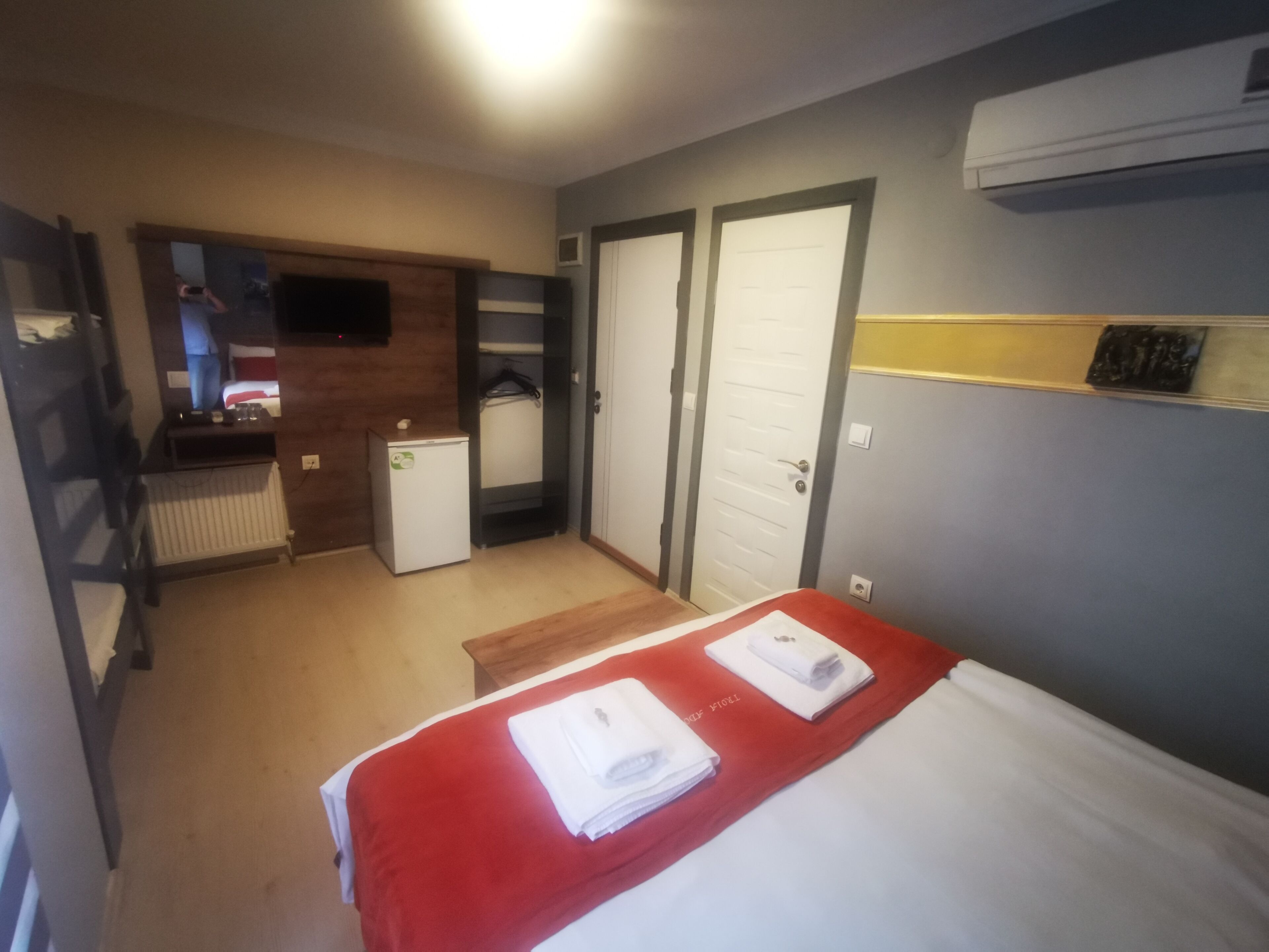 A hotel room with a bed, a small kitchenette, a walk-in closet, and a bathroom.