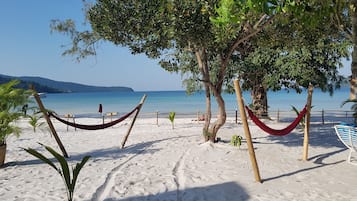 Una playa de arena blanca, una hamaca y vistas al mar.