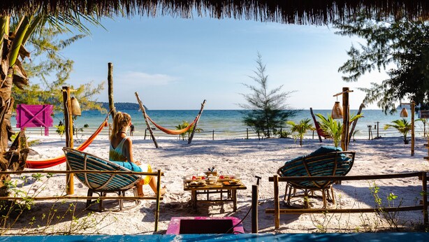 A beachside setting with two lounge chairs, a hammock, and a table with food items. - Bamboo Jam (Koh Rong Sanloem)