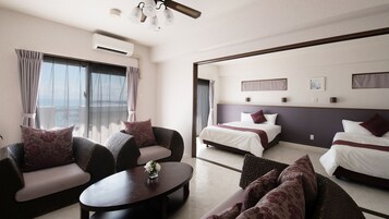Habitación de hotel con balcón, sofá, cama y mesita de café.