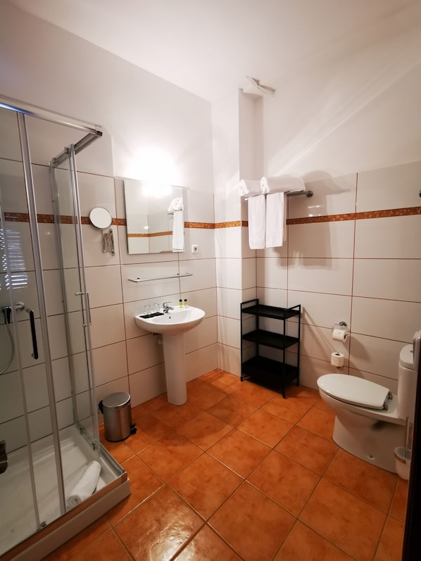 A bathroom with a glass shower enclosure, a sink, a toilet, and a black shelf. - Primavera House Port Sóller formerly Sol Port Sóller (Sóller)
