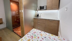 Una cocina compacta con armarios de madera, microondas y cafetera.
