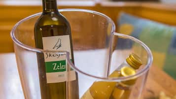 Una botella de vino Zelen y una copa con una botella de vino Fruska sobre una mesa de madera.