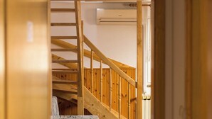 Una escalera que lleva a un piso superior, un sofá estampado y un piso con baldosas.
